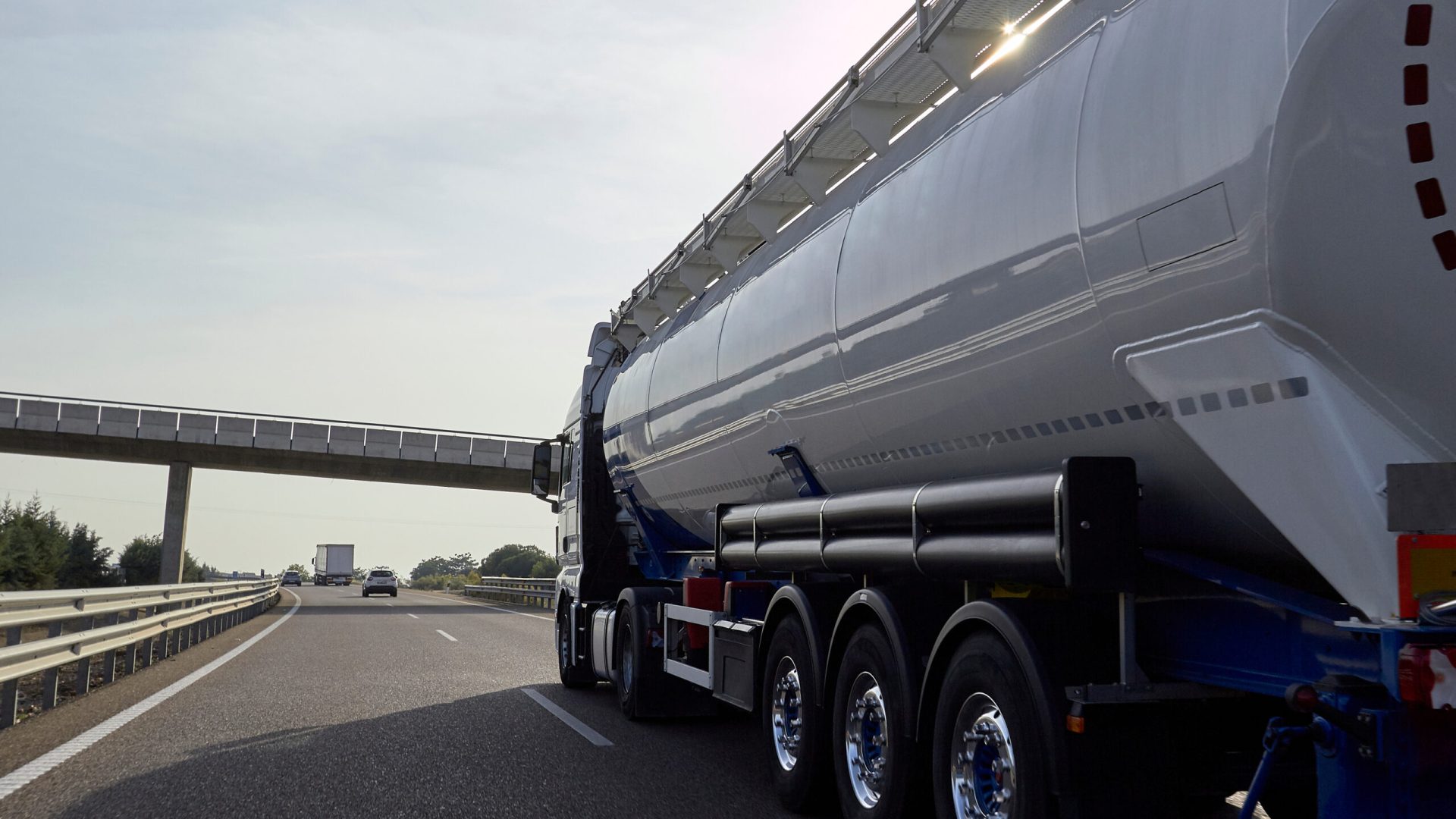 Bulk goods silo tanker truck driving on highway road.